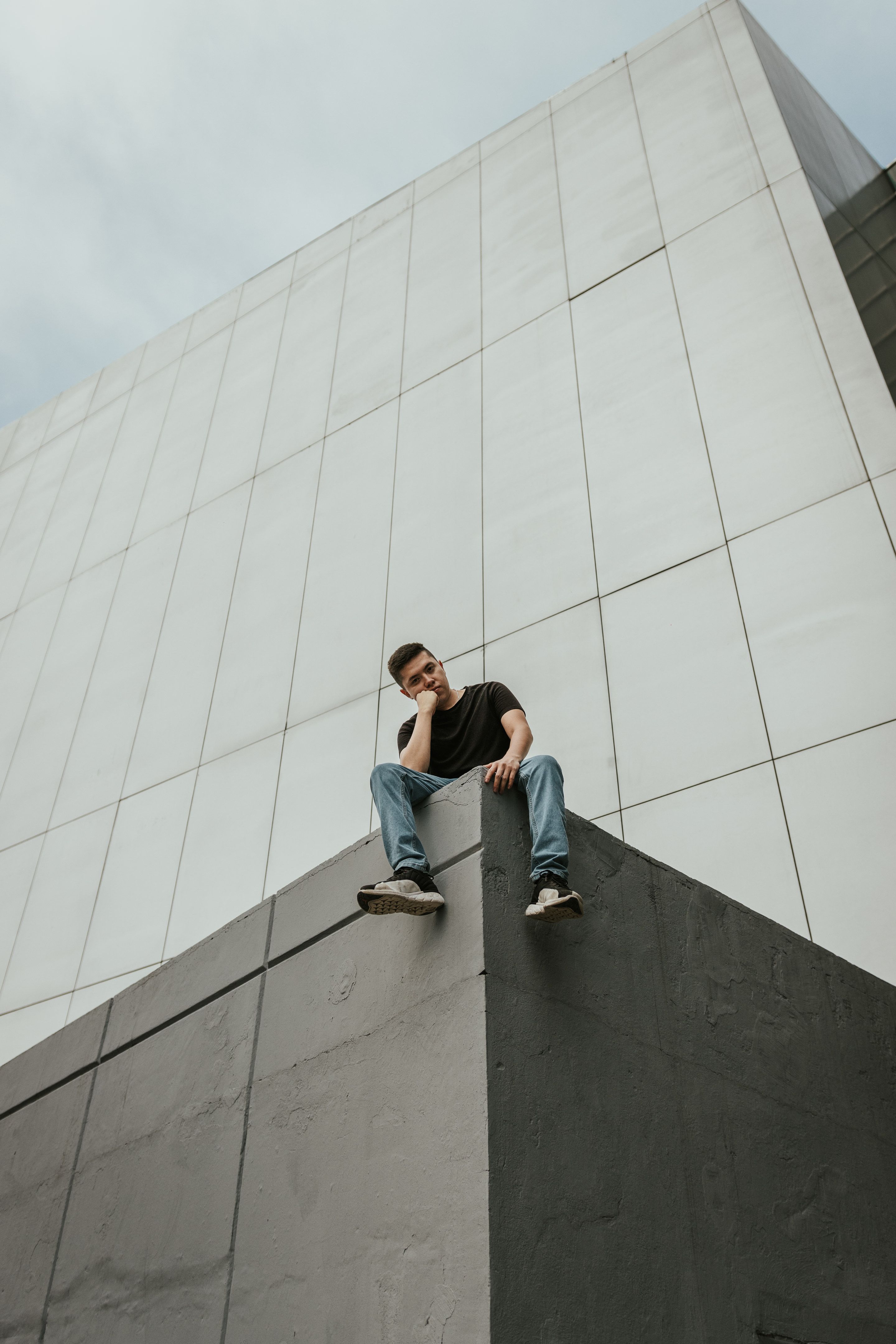MIKEGAUZZE seated on a concrete ledge